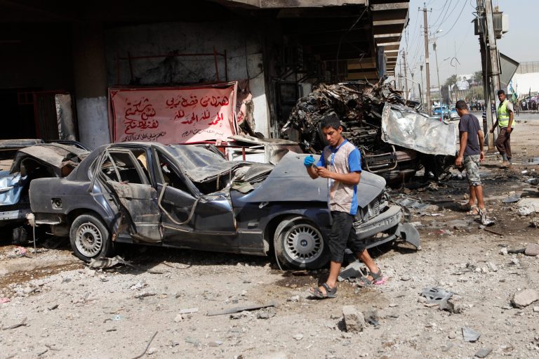   People inspect the scene of a car bomb attack in the Karrada neighborhood of Baghdad, Iraq, Wednesday, June 13, 2012. Wave of bombings targeted religious processions during the annual pilgrimage commemorating the 8th century death of a revered Shiite imam, killing and wounding scores of people, police said. (AP Photo/Karim Kadim)  