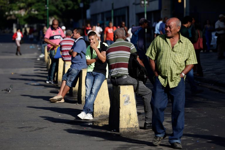 Passengers wait for available taxis or minivans that provide transportation, at a bus stop, in Rio de Janeiro, Brazil, Tuesday, May 13, 2014.  Millions of passengers in Brazil's second largest city have been stranded as Rio's bus drivers go on a 48-hour strike demanding higher pay. (AP Photo/Hassan Ammar)
