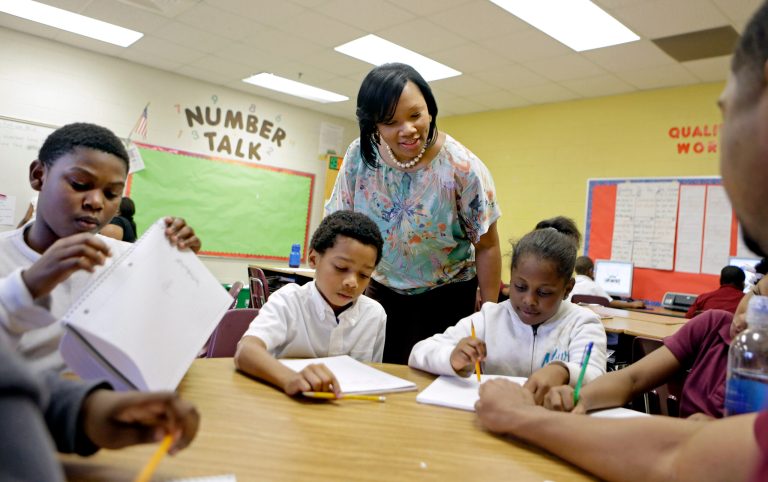   FILE - In this April 18, 2013, file photo, Burgess-Peterson Elementary School principal Robin Robbins, center, meets with students during an after-school study program in Atlanta, in preparation for state standardized testing, soon to begin. A new poll from the Associated Press-NORC Center for Public Affairs Research finds parents of school-age children view standardized tests as a useful way to track student progress and school quality. Most parents say their own children are given about the right number of standardized tests, according to the AP-NORC poll. And almost three quarters say they favor changes that would make it easier for schools to fire poorly performing teachers. (AP Photo/David Goldman)  