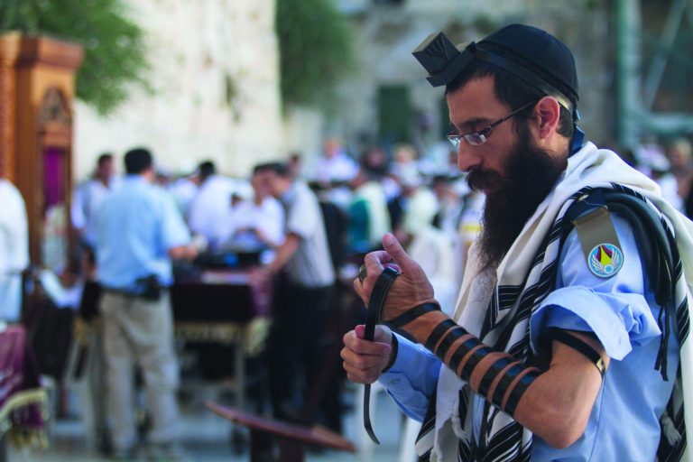 In this Monday, July 2, 2012 an Israeli soldier prays next to the Western Wall, the holiest site where Jews can pray, in Jerusalem's Old City. Deep in the heart of Mea Shearim, a Jerusalem bastion of hardline ultra-Orthodox Jews, hundreds of bearded young men in black suits have their noses burrowed into books, immersed in biblical study and oblivious to their surroundings. These young men, and their sheltered lifestyle, are at the heart of a battle that is tearing Israel apart in a clash between tradition and modernity, religion and democracy. The fight centers on whether ultra-Orthodox males should be drafted into the military along with other Jews, but it really is about a much deeper issue: the place of Judaism in the Jewish state. (AP Photo/Dan Balilty)