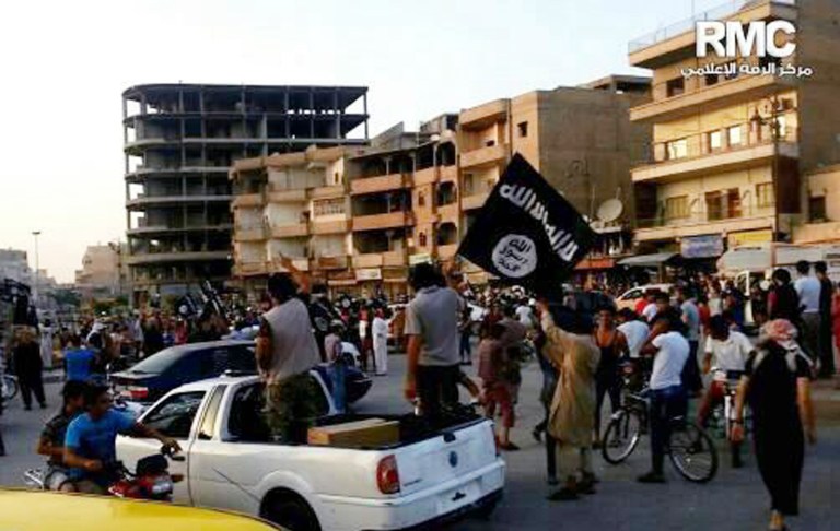 In this undated file photo posted on Monday, June 30, 2014 by the Raqqa Media Center, fighters from extremist Islamic State of Iraq and Syria parade in Raqqa, Syria. (AP Photo/Raqqa Media Center of the Islamic State group, File)