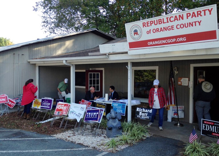 Workers at the Orange County GOP office set up a makeshift operation with folding tables on Monday, Oct. 17, 2016 in Hillsborough, N.C. Authorities are investigating the campaign office after it was was torched by a flammable device and someone spray-painted an anti-GOP slogan, damaging the interior. (AP Photo/Jonathan Drew)