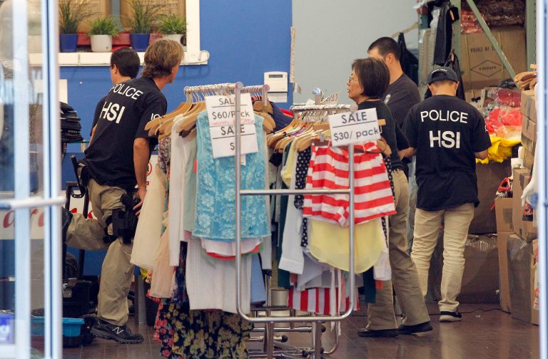 Law enforcement agents check a clothing store during a raid in the Los Angeles Fashion District Wednesday, Sept. 10, 2014. U.S. agents raided dozens of businesses in the fashion district of Los Angeles early Wednesday as part of an investigation into suspected money laundering done for Mexican drug cartels. (AP Photo/ Nick Ut )