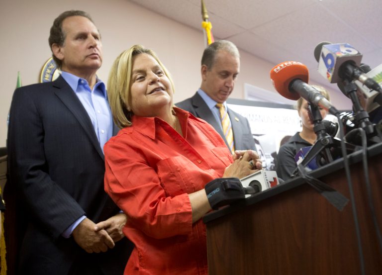 U.S. Rep. Ileana Ros-Lehtinen, R-Fla., center, listens to a question from the media as she is joined by U.S. Rep. Mario Diaz-Balart, R-Fla., right, and his brother, former Congressman Lincoln Diaz-Balart, during a news conference, Wednesday, Aug. 12, 2015, in Miami. (AP Photo/Wilfredo Lee)