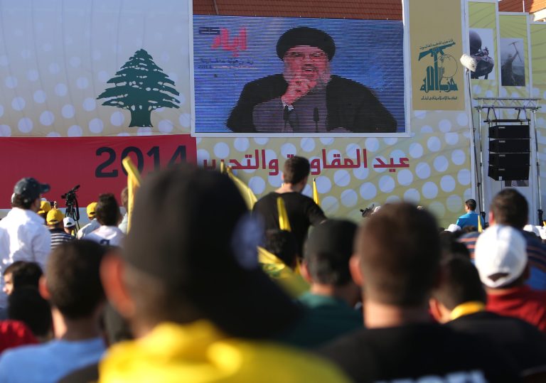 Hezbollah leader Sheik Hassan Nasrallah, center top, delivers a broadcast speech during a rally commemorating 
