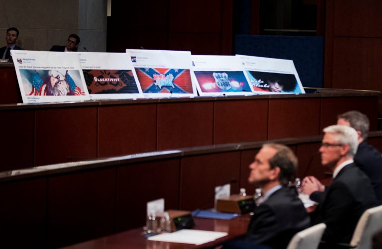Facebook ads linked to a Russian effort to disrupt the American political process are displayed as, from left, Google's Senior Vice President and General Counsel Kent Walker, Facebook's General Counsel Colin Stretch, and Twitter's Acting General Counsel Sean Edgett, testify during a House Intelligence Committee hearing on Capitol Hill on Nov. 1. (AP Photo/Manuel Balce Ceneta)