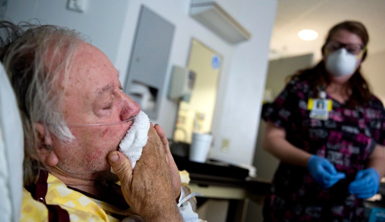Henry Beverly, 73, battles the flu while tended to by nurse Kathleen Burks at Upson Regional Medical Center in Thomaston, Ga., Friday, Feb. 9, 2018. The Centers for Disease Control and Prevention said on Friday that the peak of this flu season appears to have occurred at the beginning of February. (AP Photo/David Goldman)