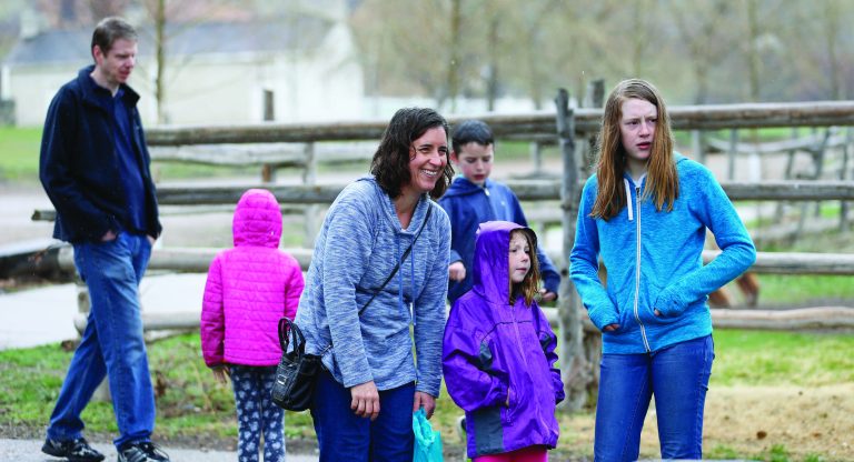 FILE - In this April 6, 2018, file photo, Amy Coulter, center, and her husband Mark, left, play with their children at the Place Heritage Park in Salt Lake City. Hundreds of new Utah laws are going into effect governing alcohol signs, medical marijuana and first-in-the-nation protections for hands-off parenting.Tuesday, May 8, 2018, is the trigger for most of the more than 500 laws passed by the Utah Legislature this year, 60 days after the end of the short legislative session. Among them is the state's so-called "free-range" parenting law, which protects parents whose children are able to take small trips alone. (AP Photo/Rick Bowmer, File )