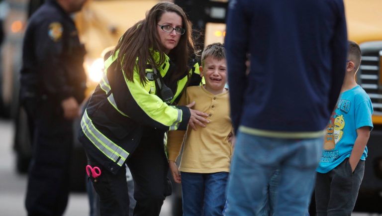Officials guide students off a bus and into a recreation center where they were reunited with their parents after a shooting at a suburban Denver middle school Tuesday, May 7, 2019, in Highlands Ranch, Colo. 