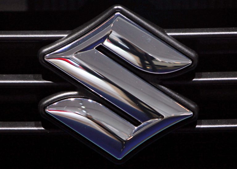 FILE - This Sept. 16 2009 file photo shows the logo of automaker Suzuki at the Frankfurt Auto Show in Frankfurt, Germany. Suzuki is recalling nearly 26,000 midsize cars in the U.S. because the daytime running light modules can overheat and could cause a fire. The recall covers the Verona from the 2004-2006 model years. It's an expansion of an earlier recall of the Forenza and Reno. (AP Photo/Daniel Roland, File)