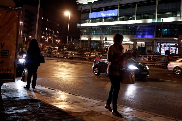 A woman walks on a sidewalk in front of the headquarters of new democracy party in Athens, Thursday, Oct. 2, 2014. Greek police foiled a planned weekend bomb attack by a far-left militant group against the headquarters of the country's ruling center-right New Democracy party, on the day it plans to celebrate its 40th anniversary. (AP Photo/Petros Giannakouris)