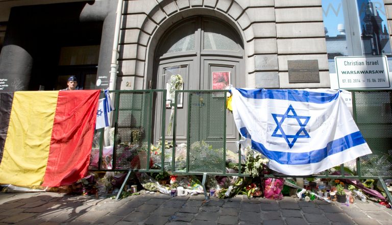 The Belgian and Israeli flag hang on a rail in front of candle and flower tributes a for the victims of a shooting at the Jewish Museum in Brussels, on Monday, June 2, 2014. Police have arrested a suspect after three people were killed and one seriously injured in a spree of gunfire at the Jewish Museum in Brussels on Saturday, May 24, 2014. (AP Photo/Virginia Mayo)