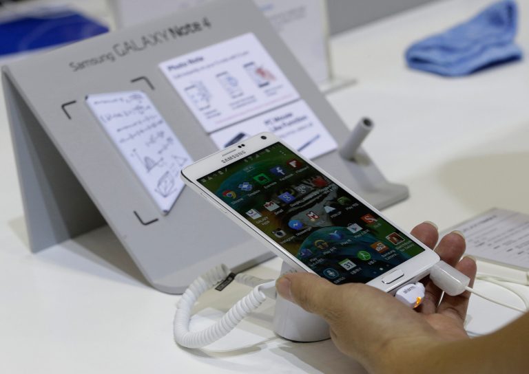 A visitor tries out a Samsung Electronics Co.'s Galaxy Note 4 smartphone during the 2014 Korea Electronics Show in Goyang, South Korea, Tuesday, Oct. 14, 2014. (AP Photo/Ahn Young-joon)