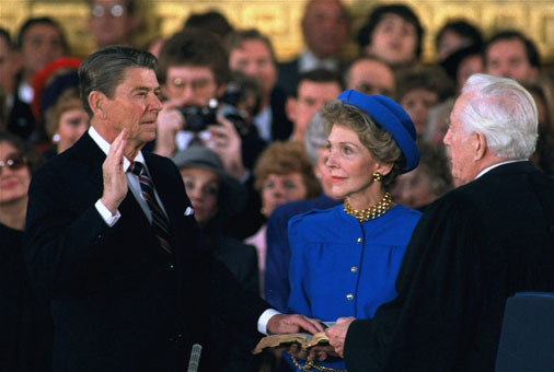 First lady Nancy Reagan watches as President Reagan is sworn in during his second inauguration in January 1985 in the Rotunda beneath the Capitol dome in Washington. Reagan, forced indoors by a record inaugural freeze, re-enacted his oath-taking. Ron Edmonds/AP