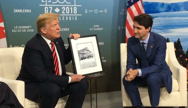 President Trump holds a photo given by Canadian Prime Minister Justin Trudeau at the G7 Summit in Canada.