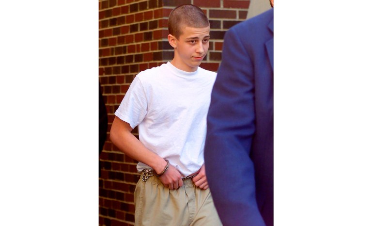 In this April 27, 2000 photo, convicted Westside Middle School shooter Andrew Golden, 13, is escorted from a back door of the Craighead County Courthouse in Jonesboro, Ark. Golden, who legally changed his name to Drew Grant, was 11 years old when he and a teenager fatally shot four students and a teacher at an Arkansas middle school more than 20 years ago. He was released in 2007. 