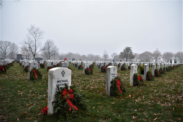 Thousands of volunteers traveled to Arlington National Cemetery on Saturday to lay wreaths at the gravesites of military service members.