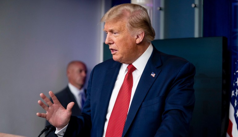 A member of the Secret Service stands guard as President Donald Trump speaks at a news conference in the James Brady Press Briefing Room at the White House, Monday, Aug. 10, 2020, in Washington. Trump briefly left because of a security incident outside the fence of the White House. 