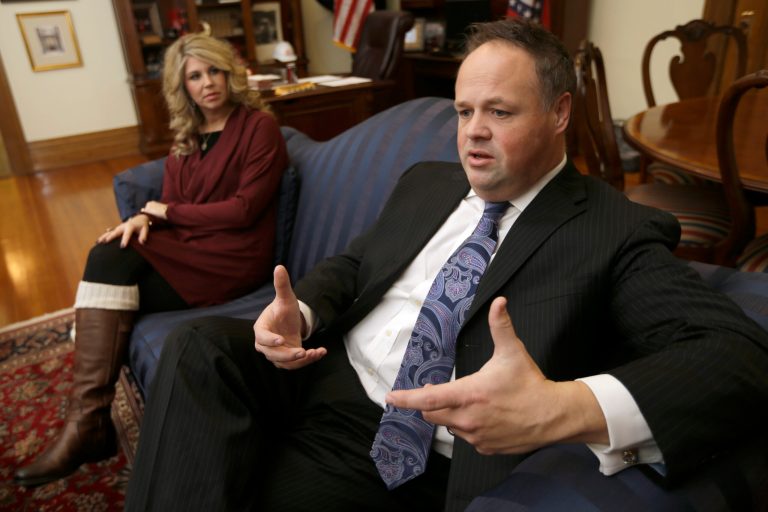 Arkansas Lt. Gov. Mark Darr, right, is interviewed at the Arkansas state Capitol in Little Rock, Ark., as his wife Kim listens Tuesday, Jan. 7, 2014. Darr said he won't resign over ethics violations tied to his campaign and office spending, despite growing calls for him to step down or face the threat of impeachment. (AP Photo/Danny Johnston)