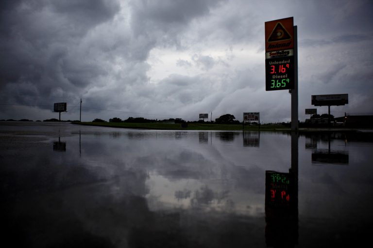  Storm clouds are reflected in the flooded parking lot of a gas station in Level Plains, Ala. after heavy rains moved through the area Sunday, June 10, 2012. (AP Photo/Dothan Eagle, Max Oden)  