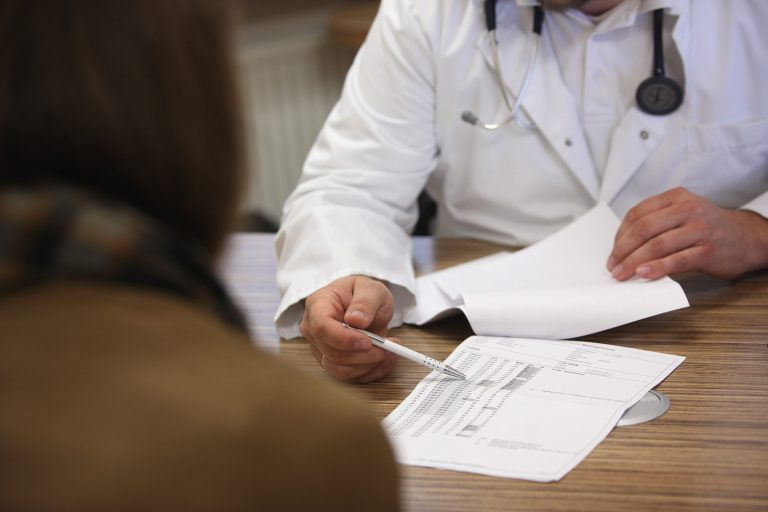 A doctor speaks with a patient. (Photo by Adam Berry/Getty Images)