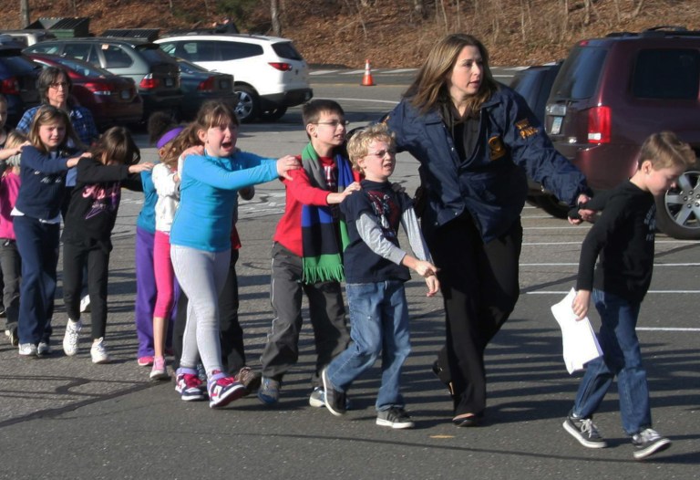   In this photo provided by the Newtown Bee, Connecticut State Police lead a line of children from the Sandy Hook Elementary School in Newtown, Conn. on Friday, Dec. 14, 2012 after a shooting at the school. (AP Photo/Newtown Bee, Shannon Hicks) MANDATORY CREDIT: NEWTOWN BEE, SHANNON HICKS  