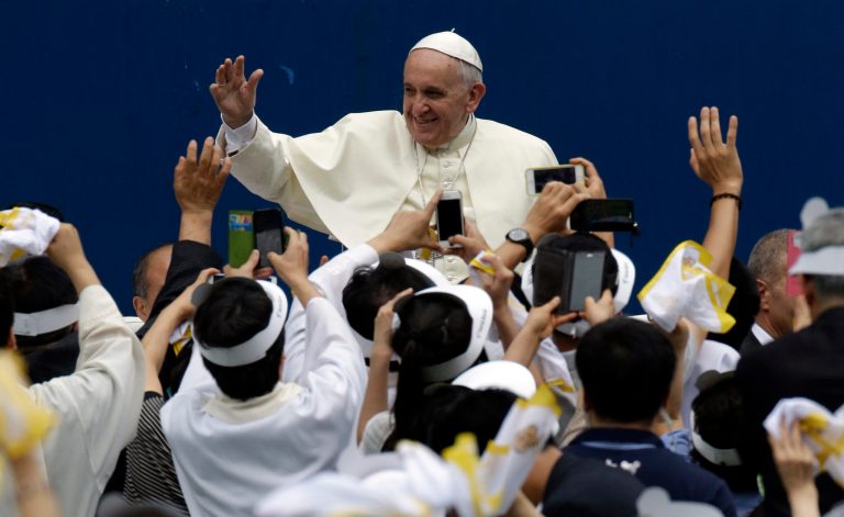 Pope Francis is greeted by the faithful upon his arrival for the Mass of Assumption of Mary at a stadium in Daejeon, south of Seoul, South Korea, Friday, Aug. 15, 2014. North Korea has Catholics. It even has a Catholic church. But while Pope Francis is being welcomed by millions of South Korean Catholics, Christianity has been largely quashed north of the border and as a string of recent arrests suggest would-be missionaries there face severe risks amid a North-South religious divide that is perhaps wider than ever. (AP Photo/Lee Jin-man, Pool)