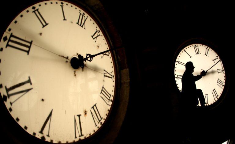 Custodian Ray Keen inspects a clock face before changing the time on the 100-year-old clock atop the Clay County Courthouse Saturday, March 8, 2014, in Clay Center, Kan. Americans will set their clocks 60 minutes forward before heading to bed Saturday night, but daylight saving time officially starts Sunday at 2 a.m. local time.(AP Photo/Charlie Riedel)