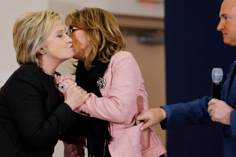 Democratic presidential candidate Hillary Clinton embraces former Arizona Rep. Gabrielle Giffords, center, and her husband astronaut Mark Kelly during a campaign stop, Wednesday, Feb. 3, 2016, in Derry, N.H. (AP Photo/Matt Rourke)