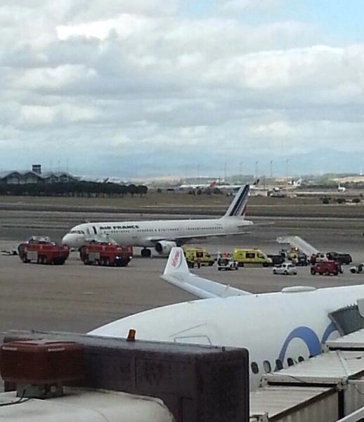 Emergency crews stand next to a plane, carrying 163 people, at the Madrid Airport, Spain, Thursday, Oct. 16, 2014. An Air France plane was isolated at Madrid's airport on Thursday because of a suspected Ebola case after a passenger was reported to have a fever and shivers, officials said. The passenger, who had traveled from Lagos, Nigeria, was taken by ambulance to an unspecified hospital in Madrid but the rest of the passengers were allowed to leave the plane as normal, Air France said in a statement. (AP Photo/Antoni Manchado)