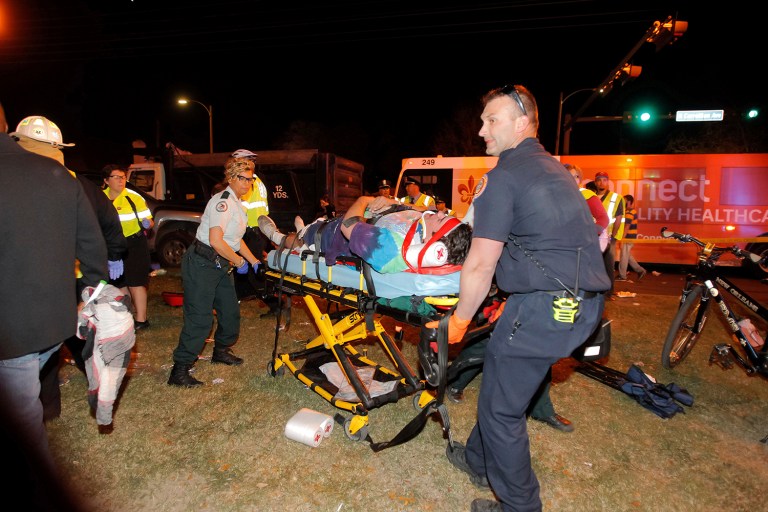New Orleans emergency personnel attend to an injured parade watcher in the Mid-City section of New Orleans, Saturday, Feb. 25, 2017. (Scott Threlkeld/The Advocate via AP)