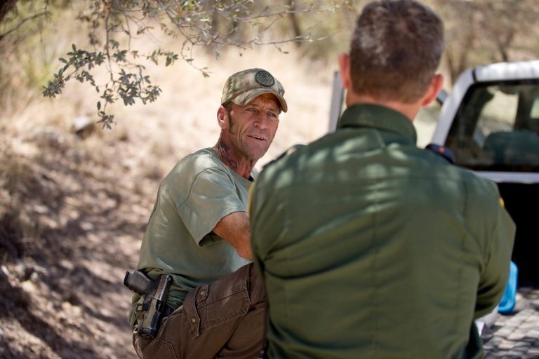 In this May 11, 2016 picture, Tim Foley speaks with a Border Patrol agent during a surveillance patrol in Sasabe, Ariz. Foley, a former construction foreman, founded Arizona Border Recon, a group of armed volunteers who dedicate themselves to border surveillance. (AP Photo/Gregory Bull)