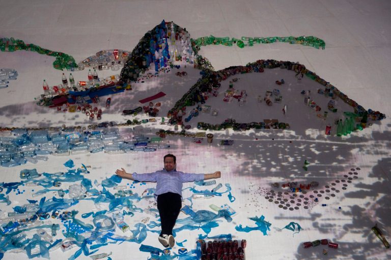   Brazilian artist Vik Muniz poses for a photo as he lies on his 