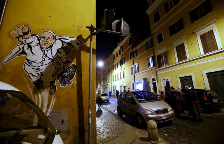 A graffiti depicting Pope Francis as Superman and holding a bag with a writing which reads: 