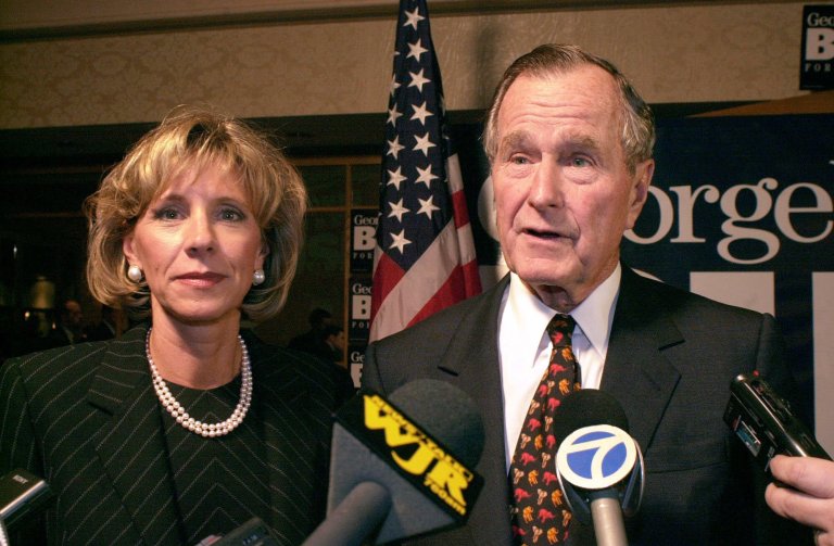 Former President George Bush, right, and Betsy DeVos, chairman of the Michigan Republican Party, answer reporters' questions Tuesday, Feb. 8, 2000, in Sterling Heights, Mich. Bush attended a fund-raising dinner in Michigan to campaign for his son, Texas Gov. George W. Bush, who is seeking the Republican nomination for president. (AP Photo/Paul Warner)