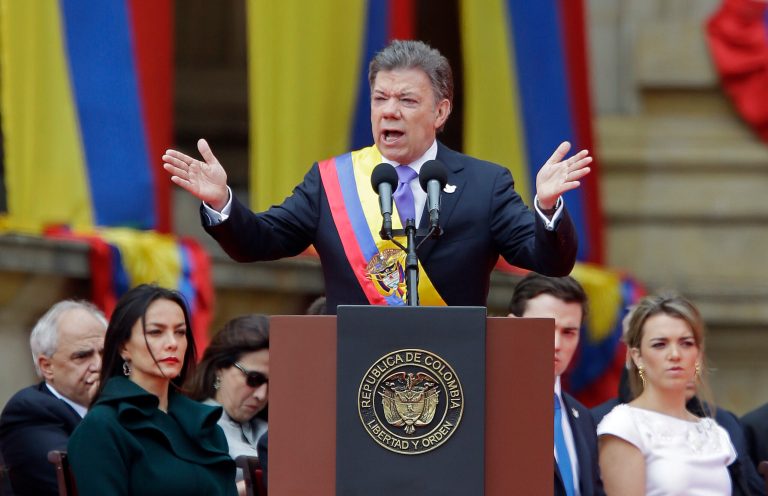 Wearing the presidential sash, newly sworn-in President Juan Manuel Santos, delivers his inaugural speech, in Bogota, Colombia, Thursday, Aug. 7, 2014. Santos, who narrowly defeated a conservative challenger to win another term, promises to redouble his efforts to end a half-century war against Marxist rebels. (AP Photo/Fernando Vergara)