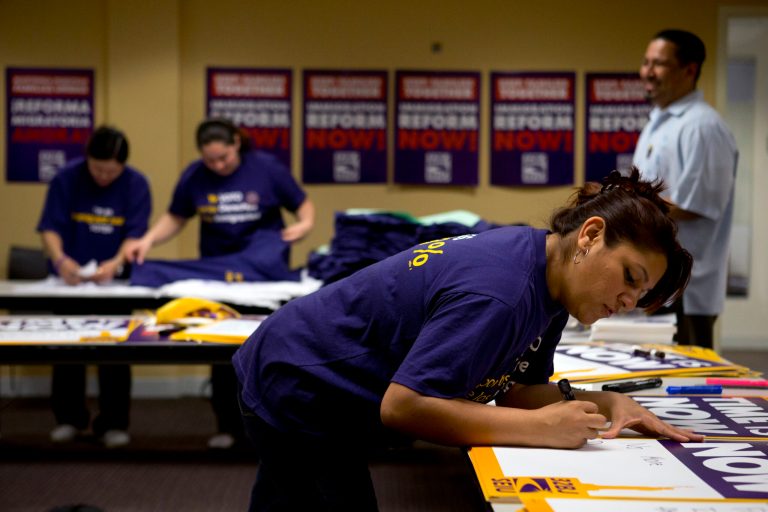 Denise Villagomez, a union member, writes on a sign as she and other union volunteers prepare for an immigration reform rally at the Service Employees International Union, which is co-organizing the rally, in Washington on April 9. (AP File)