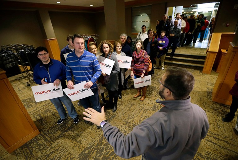 Campaign volunteer Adam Hasner of Boca Raton, Fla., right, welcomes supporters arriving to listen to Republican presidential candidate Sen. Marco Rubio, R-Fla., speak at a campaign rally, Sunday, Jan. 31, 2016. (AP Photo/Charlie Neibergall)