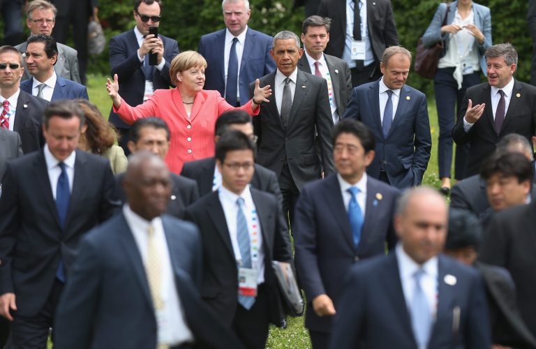 German Chancellor Angela Merkel (in pink) gestures as she, President Obama (to her right) and other world leaders at the G7 summit prepare for a group photo. (Getty Images)