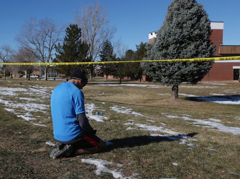 Sean Sweeney, a runner who lives near Arapahoe High School in Centennial, Colo., stops to say a prayer outside the school during his run early on Saturday, Dec. 14, 2013. The school was the scene of a shooting on Friday that left the student gunman dead and injured two other students. (AP Photo/David Zalubowski)