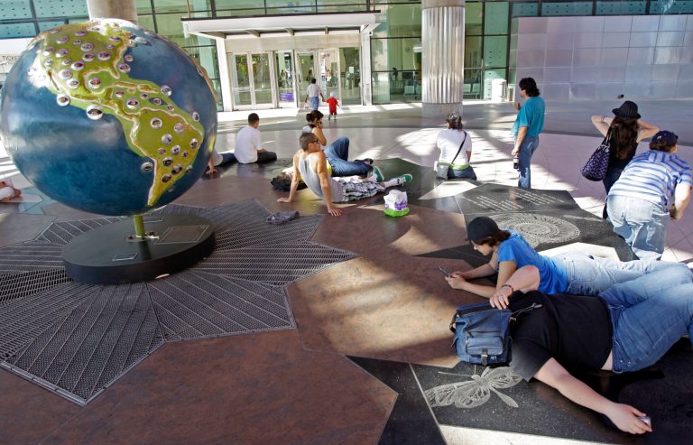 Visitors to the California Science Center take advantage of shade and relatively cooler temperatures to beat the heat. (AP Photo/Reed Saxon)