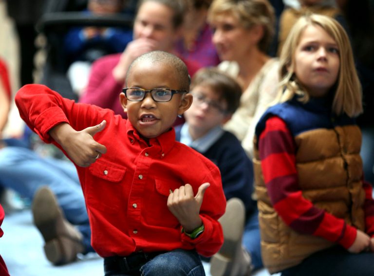 Camron Ellis signs along with Christmas carols as MacArthur Center opens its doors early at the Ice Palace for deaf and hard-of- hearing children from Hampton Roads public schools in Chesapeake, Va. (Steve Earley/The Virginian-Pilot via AP)
