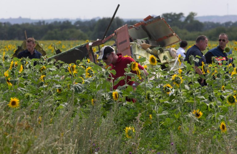 Dutch and Australian investigators examine pieces of the crashed Malaysia Airlines Flight 17 in the village of Rassipne, Donetsk region, eastern Ukraine Friday, July 25, 2014. (AP Photo/Dmitry Lovetsky)
