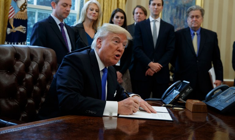 Lawyers with the American Civil Liberties Union and other legal organizations are slapping President Trump with a lawsuit after he signed an executive order Friday that temporarily bars refugees from entering the U.S. (AP Photo/Evan Vucci)