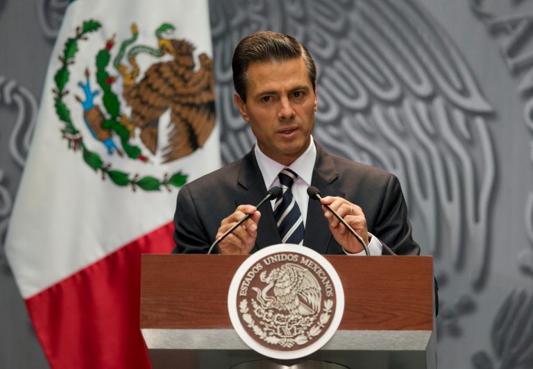 President Enrique Pena Nieto adjusts his microphones as he arrives at a press conference to express his outrage over the recent disappearance of 43 students in Guerrero State following a violent confrontation with the police, in Mexico City, Monday, Oct. 6, 2014. Guerrero state officials worked Monday to determine whether 28 bodies found in a clandestine grave are students who were attacked by police suspected of drug gang links in the southern state of Guerrero. (AP Photo/Rebecca Blackwell)