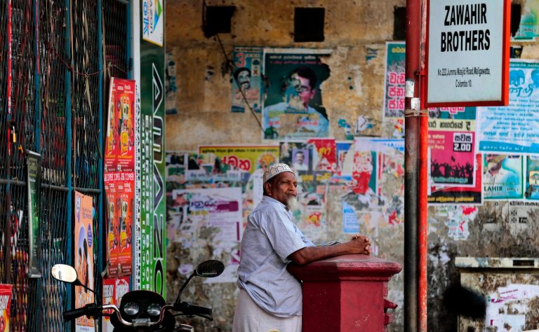 A Sri Lankan Muslim man leans against a letter box as he waits out side a closed shop during a shut down protest in Colombo, Sri Lanka, Thursday, June 19, 2014. Muslims have shut down their shops in Sri Lanka's capital to protest attacks by hard-line Buddhists on Muslims and are demanding the government punish those responsible for the violence. (AP Photo/Eranga Jayawardena)