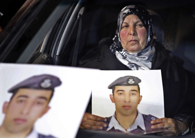 The mother of Jordanian pilot Lt. Mu'ath al-Kaseasbeh holds a picture of her son, who is held by Islamic State group militants, in a car during a sit-in in front of the cabinet offices in Amman, Jordan. (AP/Raad Adayleh)