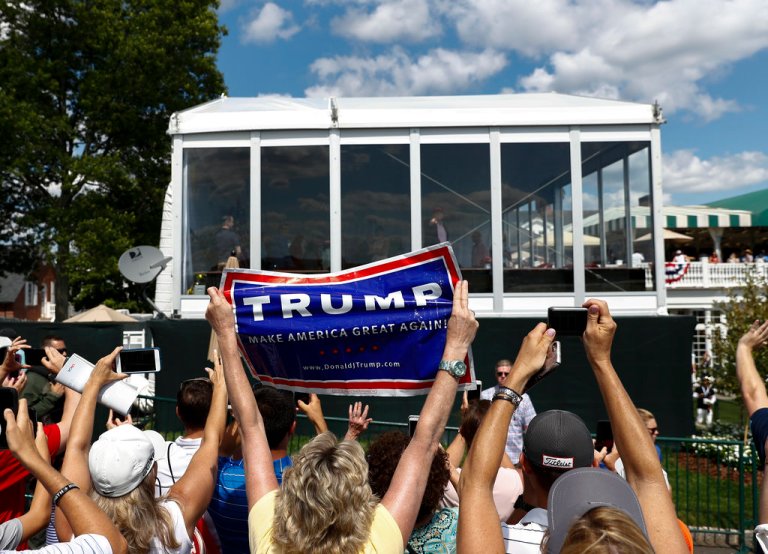 U.S. President Donald Trump points to a cheering crowd from his presidential viewing stand, Sunday, July 16, 2017, during the U.S. Women's Open Golf tournament at Trump National Golf Club in Bedminster, N.J. (AP Photo/Carolyn Kaster)