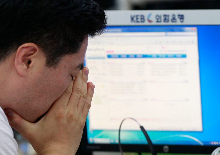 A currency trader reacts as he works at the foreign exchange dealing room of the Korea Exchange Bank headquarters in Seoul, South Korea, Friday, July 11, 2014. Asian stock markets were muted Friday, following the lead of Wall Street traders spooked by worries about the soundness of a bank in Portugal that raised the specter of more financial turmoil in Europe. South Korea's benchmark Kospi dropped 0.70 percent at 1,988.74.( AP Photo/Ahn Young-joon).
