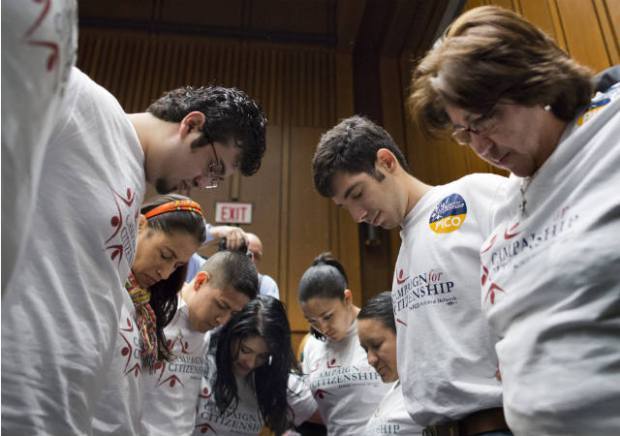 Immigration reform advocates pray before the start of a Senate Judiciary Committee meeting in May. (AP Photo/J. Scott Applewhite)